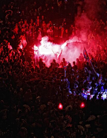 Un grupo de aficionados encienden bengalas durante la celebración en la Plaza de Neptuno