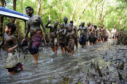 Un grupo de balineses bañan su cuerpo en barro durante el baño tradicional conocido como 'Mebuugbuugan', en el pueblo de Kedonganan (Bali).