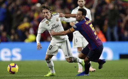 Modric y Busquets pugnan por un balón en el último clásico.