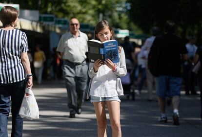 Una niña lee un libro de Gabriel García Marquez durante su visita a la Feria del Libro de Madrid, 9 de junio de 2014.