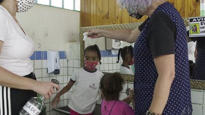 Dos maestras ayudan con el lavado de manos a las niñas del colegio infantil de Guaianases. Los cuidados que exige la pandemia han duplicado cualquier tarea, incluso las más sencillas. Pero, a pesar de las restricciones, los alumnos parecen estar contentos de regresar a las clases presenciales. Necesitaban al menos un poco de contacto humano con sus compañeros.