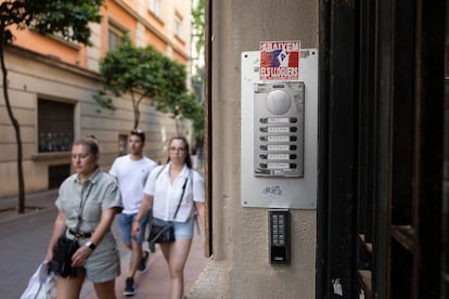 Entrada al edificio de Gràcia donde los vecinos conviven con pisos con habitaciones de alquiler. Los dos perfiles tienen distinta botonera para entrar a la finca.