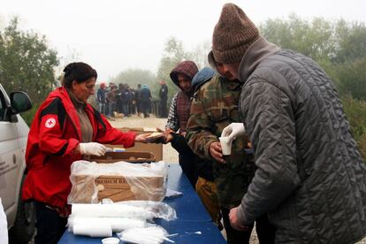 La Cruz Roja bosnia entrega el desayuno a los migrantes y refugiados en Velika Kladusa. Al fondo, la cola de espera.