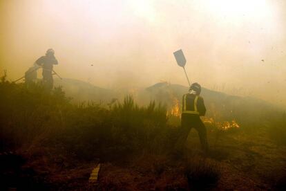 Bomberos de la zona durante las labores de extinción en el pueblo de Requías.