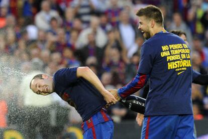 Piqué baña con champán a Iniesta en el césped del Camp Nou.