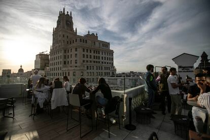 Unos clientes disfrutan del atardecer con vista al edificio de Telefónica en la Gran Vía. 