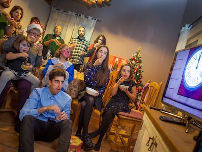 Una familia toma las doce uvas en fin de año.