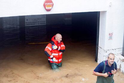 Dos bomberos trabajan en uno de los garajes inundados este viernes en Alcocéber (Castellón).