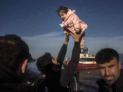 Un iraquí, procedente de la ciudad de Mosul (ocupada por el ISIS), sostiene a su hija tras llegar en un pequeño bote, junto a otros 150 refugiados, a la isla de Lesbos este martes.
