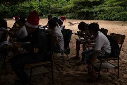 Niños reciben clase debajo de un árbol, en la escuela La Voluntad de Dios.