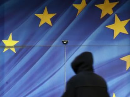 Un hombre pasa ante una bandera de la UE.