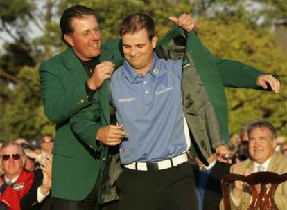 Phil Mickelson pone la chaqueta verde al ganador del Masters, Zach Johnson.