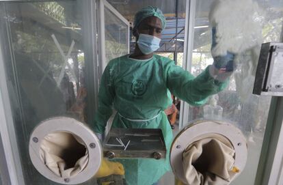 Un operario desinfecta una cabina para la realización de pruebas contra el coronavirus, en Karachi (Pakistán).