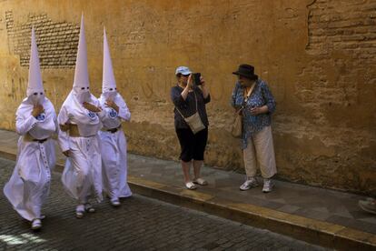 Unas turistas hacen fotos durante la Semana Santa en Sevilla, el 16 de abril de 2019.