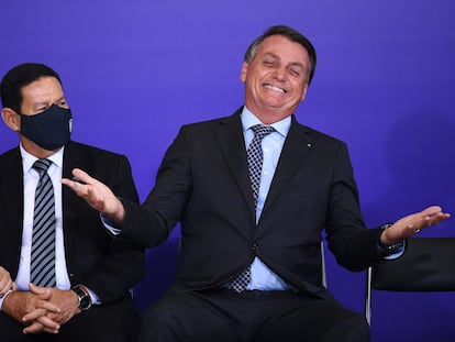 Bolsonaro é observado pelo vice, Hamilton Mourão, durante cerimônia no Palácio do Planalto, na segunda.