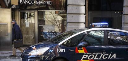 Un coche de polic&iacute;a aparcado frente a la oficina de Banco Madrid.