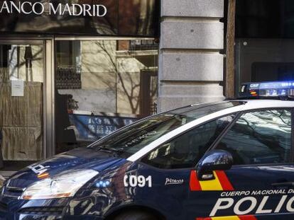 Un coche de polic&iacute;a aparcado frente a la oficina de Banco Madrid.