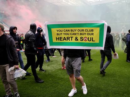 Un aficionado del United, en Old Trafford con una cartel que dice: "Tú puedes comprar nuestro club, pero no nuestro corazón y nuestra alma".