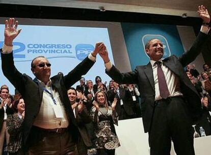 Francisco Camps levanta la mano de Carlos Fabra, ayer, tras su reelección en el congreso provincial del PP celebrado en Peñíscola.