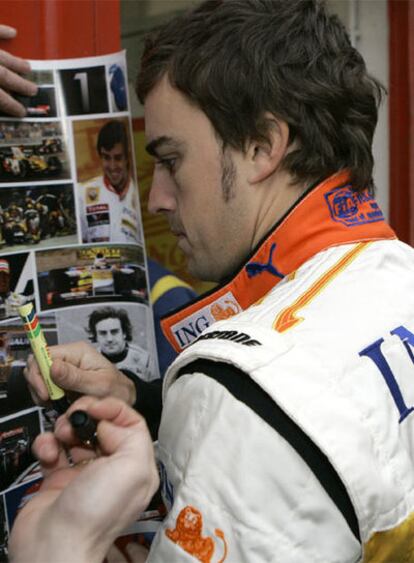 Fernando Alonso firma autógrafos ayer en Montmeló.