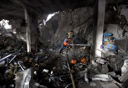 Bomberos palestinos apagan las llamas de un edificio destruido en la ciudad de Gaza, el 11 de julio de 2014.