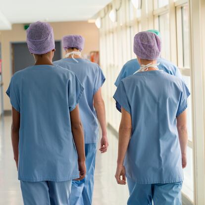 Rear view of a medical team walking in the corridor of a hospital
