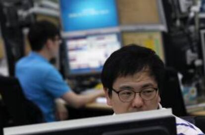 Un corredor de bolsa surcoreano observa los monitores en la sede del Exchange Bank de Seúl (Corea del Sur).