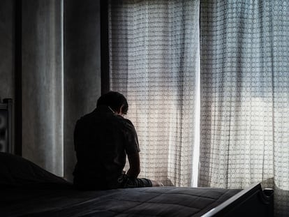 Lonely young man depressed and stressed sitting in the dark bedroom, Negative emotion concept