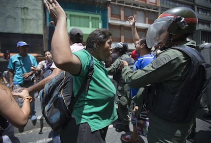 La angustia por las varias horas de espera en filas interminables y el temor de no encontrar alimentos se han convertido en el mejor combustible para las protestas que se viven a diario en las calles de Caracas, donde chocan constantemente chavistas y ciudadanos que se dicen 'cansados' de la crisis. En la imagen, una mujer se enfrenta a un soldado de la Guardia Nacional a pocos metros del palacio presidencial de Miraflores, en Caracas.