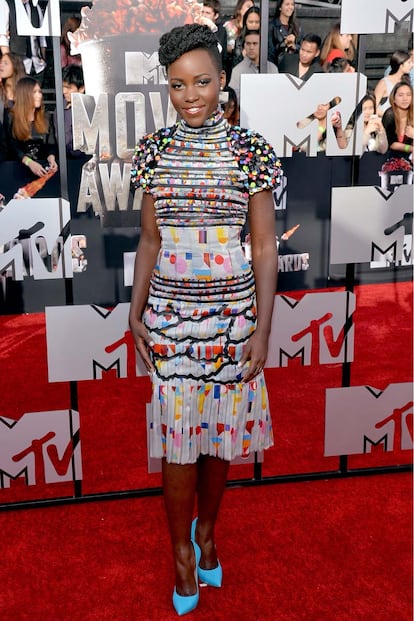 Lupita Nyong'o pone esta semana el punto de color a la galería. La actriz de 12 años de esclavitud ha sido una de las más aclamadas sobre la alfombra roja de los MTV Movie Awards. Con uno de los diseños que hace unos meses vimos en el 'supermercado' de Karl Lagerfeld, Nyong'o completó el conjunto con discretos y sencillos complementos. Nos encanta.