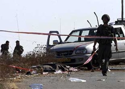 Un policía israelí, en el norte de Cisjordania, en el lugar donde extremistas palestinos ametrallaron ayer un autobús.