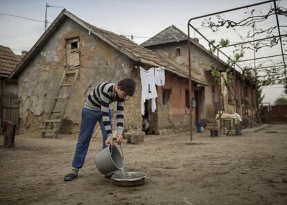 Los niños a menudo tienen que subsistir sin los alimentos necesarios, ropa de abrigo o instalaciones de baño adecuadas. En la foto, un niño pone agua a las gallinas en el corral de su casa en Beregardo, en Transcarpatia (Ucrania), el 6 de mayo de 2017.