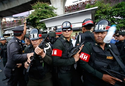 Un bote de agua es lanzado a un grupo de soldados durante una protesta en el centro de Bangkok (Tailandia). La Junta Militar de Tailandia anunció que ha puesto en libertad a 124 de las 253 personas que convocó tras el golpe de Estado del día 22, al tiempo que endureció la censura y prosiguió con la elección de mandos policiales y administrativos.