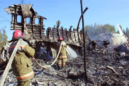 Efectivos del cuerpo de bomberos trabajan en los restos del fuselaje del Il-86 siniestrado.