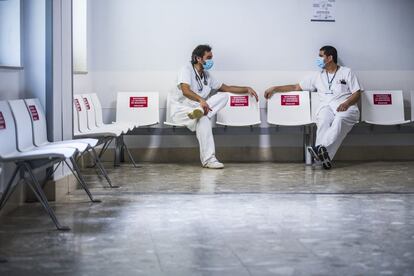 Los médicos internistas Sergio Diz (a la izquierda) y Fernando Hidalgo, en una planta de hospitalización de enfermos de covid. Diz, también microbiólogo, siente que la pandemia le ha enseñado muchas cosas, pero ha experimentado situaciones muy duras. No solo por el altísimo número de personas que fallecían. "Ha habido pacientes que me pedían que les sedara. No querían seguir siendo conscientes de lo que estaban pasando"., asegura. "La crisis ha hecho que se haya ido una avalancha de gente que aún no les tocaba irse". Cree que el hospital ha cambiado. "Somos más solidarios, más colaboradores, nos hemos conocido más".