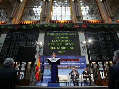 Zapatero explica su informe económico en la sala principal de la Bolsa de Madrid. Detrás, Pedro Solbes y David Taguas.