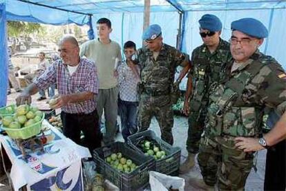 Varios soldados españoles compran manzanas a un frutero de Taibé.