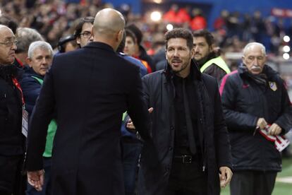 El entrenador del Real Madrid Zinedine Zidane (i) saluda al entrenador del Atlético de Madrid Diego Simeone.