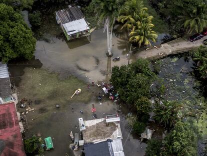 Una familia convive en el frente de su casa completamente inundada en la zona de El Zapote. 