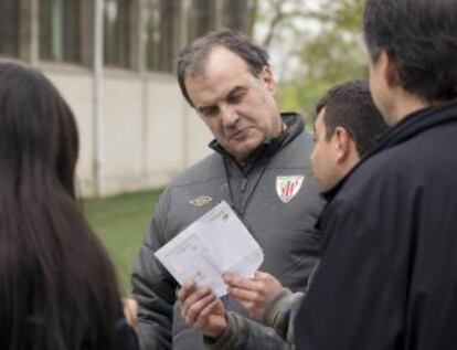 Marcelo Bielsa con unos aficionados a la salida de Lezama.