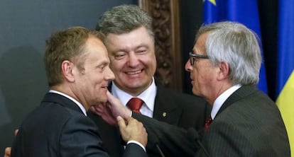 De izquierda a derecha, Donald Tusk, Petr&oacute; Poroshenko y Jean-Claude Juncker, el lunes en Kiev.