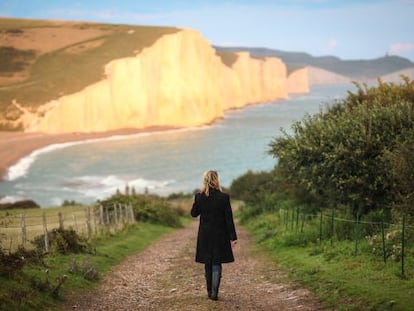 Una mujer camina hacia los acantilados de creta de Seven Sisters, en Sussex (Inglaterra).