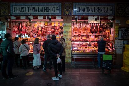 Clientes en una puesto del mercado de Triana en Sevilla, el martes.