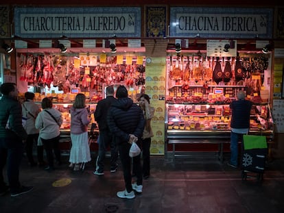 Clientes en una puesto del mercado de Triana en Sevilla, el martes.