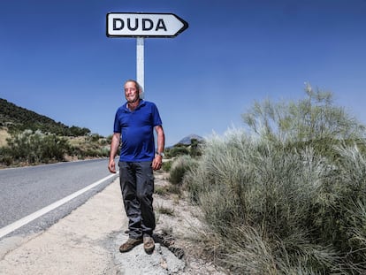 El pastor Domingo González posa delante de la señal que conduce a su pueblo: Duda (Granada).