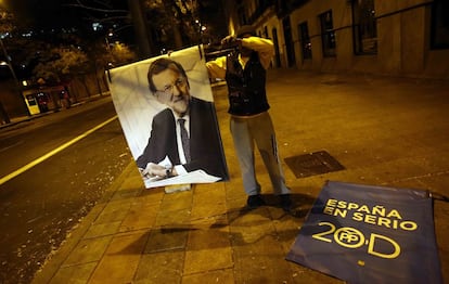 Un operario recoge los carteles electorales de Mariano Rajoy en una calle de Madrid.