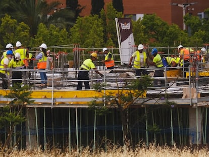 Obreros trabajan en un edificio de  viviendas en Sevilla, este martes. PACO PUENTES