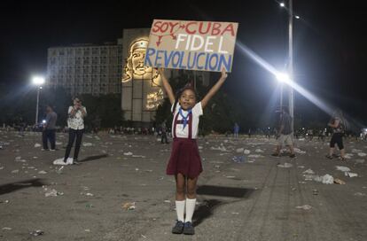 Una niña posa para la foto con una pancarta a favor de Fidel Castro tras la ceremonia, en la Plaza de la Revolución. 