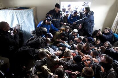 Policías israelíes intentan desalojar los colonos de una casa durante la evacuación del asentamiento judío de Amona.