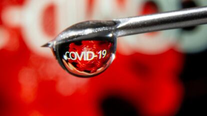 FILE PHOTO: The word "COVID-19" is reflected in a drop on a syringe needle in this illustration